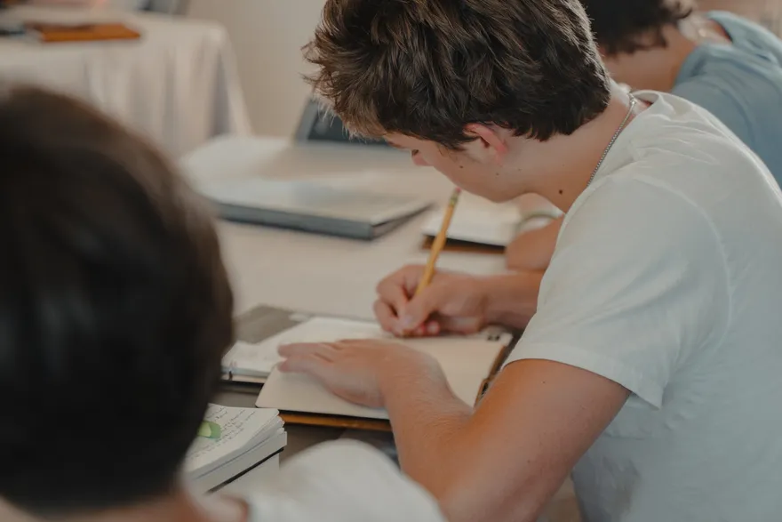 A 2026 LeapYear student writing in a journal during the kickoff retreat