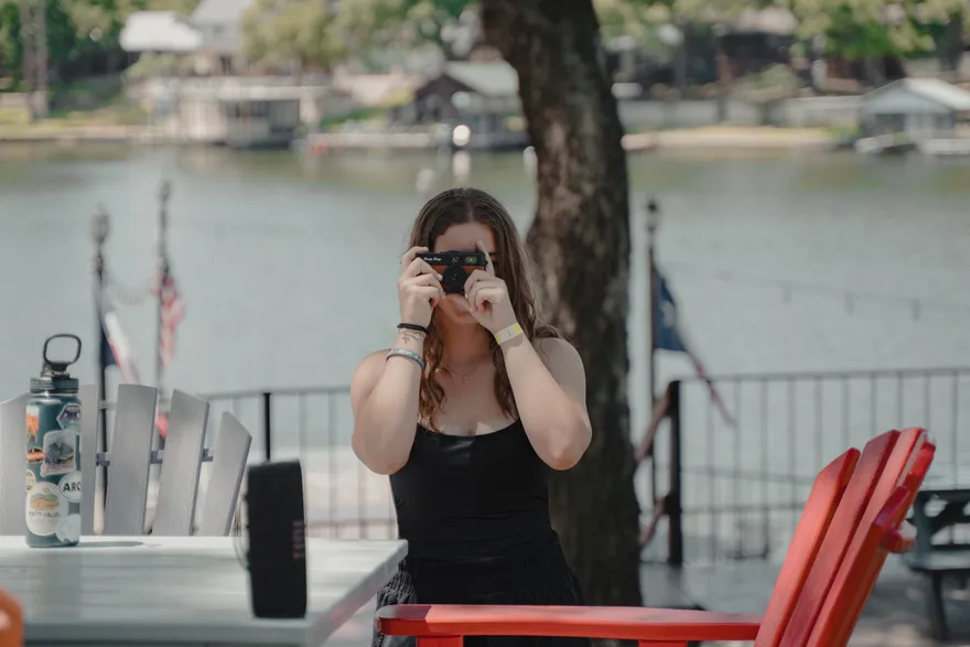 A 2026 LeapYear student taking a photograph beside the lake