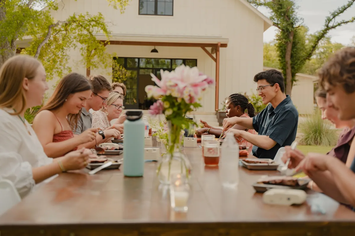 LeapYear students sharing a meal around a long table