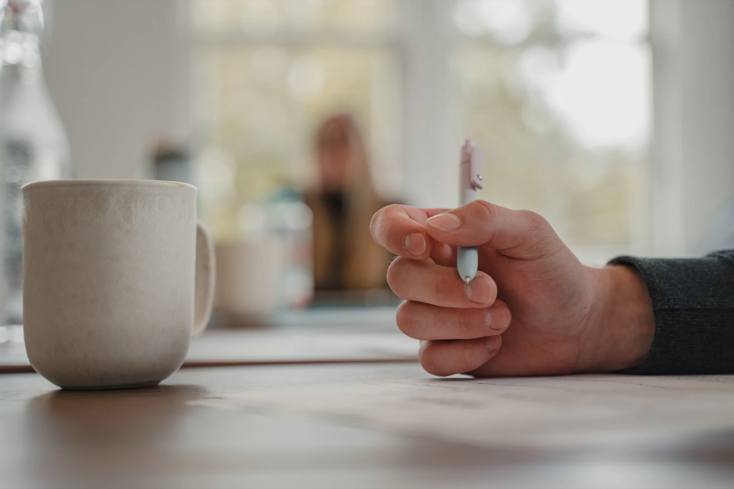 A hand holding a pen during a LeapYear retreat reflection