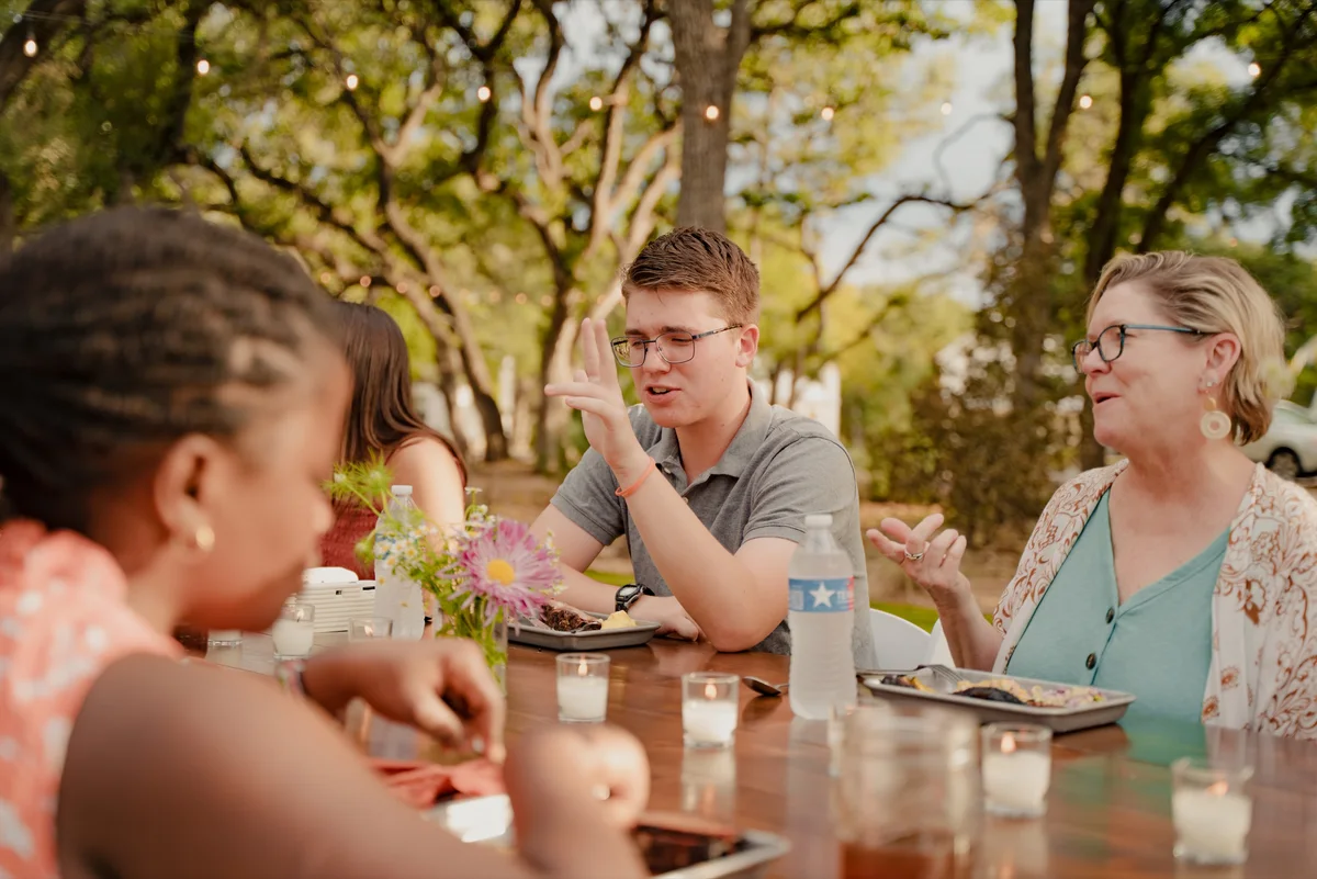 A LeapYear student in conversation with mentors around an outdoor table